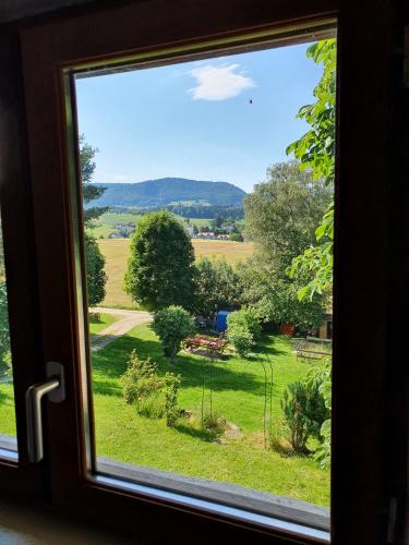 a view of a field from a window at Gîte de la Motte in Tavannes