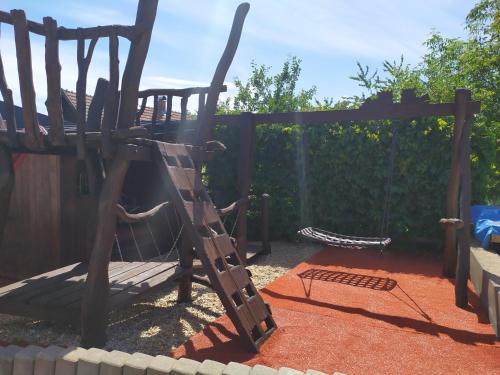 a playground with a wooden swing set in a backyard at Ubytování U Bohouše in Jilemnice