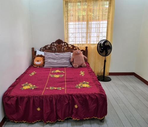 a bedroom with a bed with two stuffed animals on it at Simply Ur Home in Lucena in Lucena