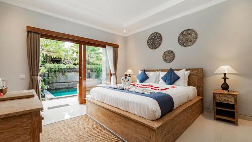 una camera con un grande letto e una grande finestra di Ayu Sari Guesthouse by Mahaputra ad Ubud