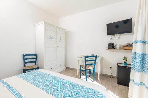 a bedroom with a bed and two chairs and a desk at Sa Domm'e Galleria in Baunei