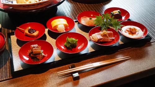 a group of plates of food on a table with chopsticks at Yuzuya Ryokan in Kyoto