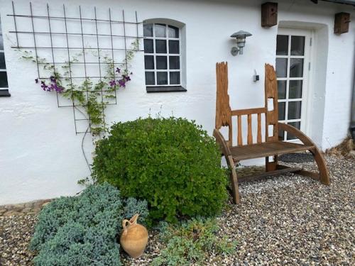 a bench sitting in front of a house at Guldforhoved B&B in Bording Kirkeby