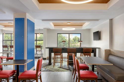 a restaurant with tables and chairs and a bar at Holiday Inn Express & Suites Greenville-Downtown, an IHG Hotel in Greenville