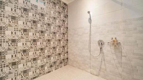 bagno con doccia e soffione di Ayu Sari Guesthouse by Mahaputra ad Ubud