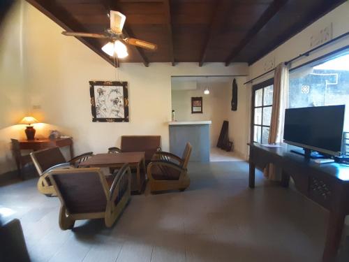 a living room with a table and a television at Puri Kutat Lestari in Sanur