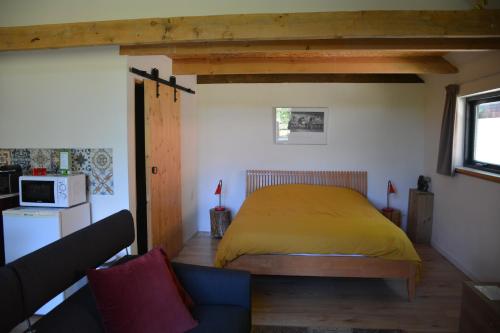 a bedroom with a yellow bed in a room at Tijdzat in Haaren