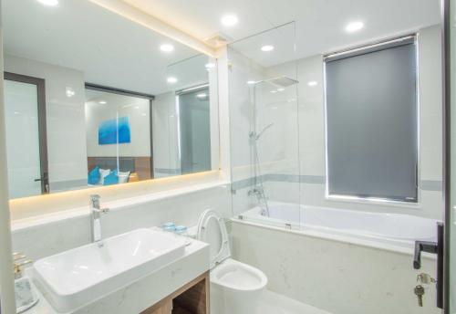 uma casa de banho branca com um lavatório e um chuveiro em Mystery Villas & Spa Cam Ranh em Cam Lâm