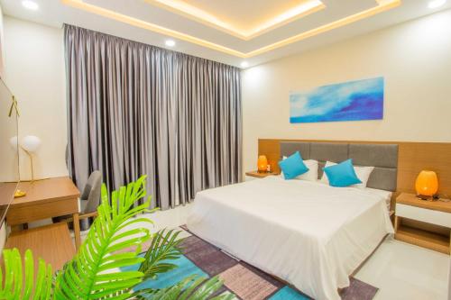 a bedroom with a bed with blue pillows at Mystery Villas & Spa Cam Ranh in Cam Lâm