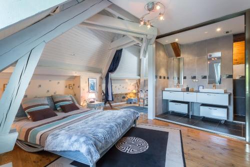 een slaapkamer met een groot bed en een badkamer bij Le Berthoir in Pélussin