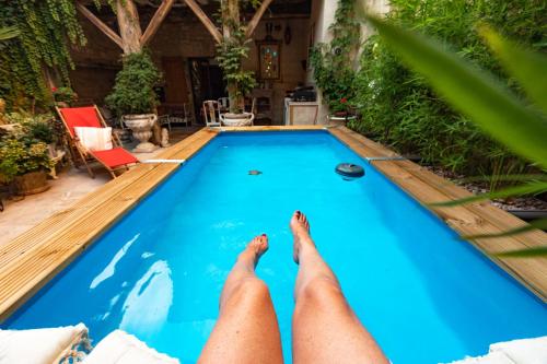 a person laying on the edge of a swimming pool at Champagne House - Elegance, Luxury and Charm in Condom