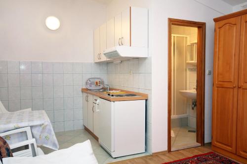 a small kitchen with a counter and a sink at Studio Drvenik Gornja vala 4890e in Drvenik