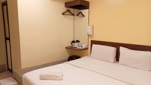 a hotel room with a bed with a towel on it at Dream House Hotel in Skudai