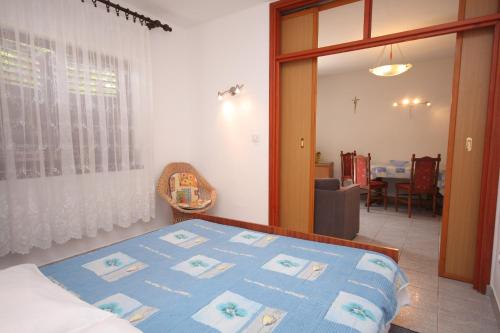 1 dormitorio con 1 cama con manta azul en Studio Tisno 5091c en Tisno