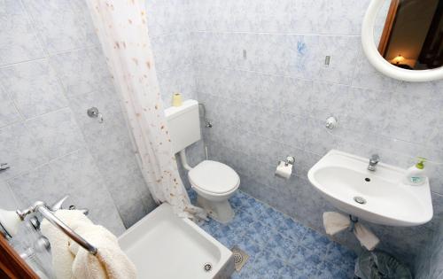 a bathroom with a white toilet and a sink at Twin Room Saplunara 4907b in Saplunara