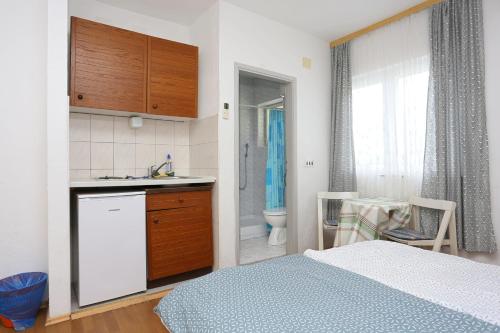 a bedroom with a bed and a sink and a bathroom at Studio Tucepi 6695a in Tučepi