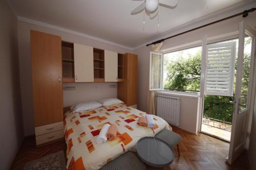 a bedroom with a bed and a large window at Double Room Banjol 5077b in Rab