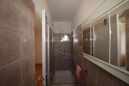 a bathroom with a shower with a glass door at Double Room Banjol 5077b in Rab