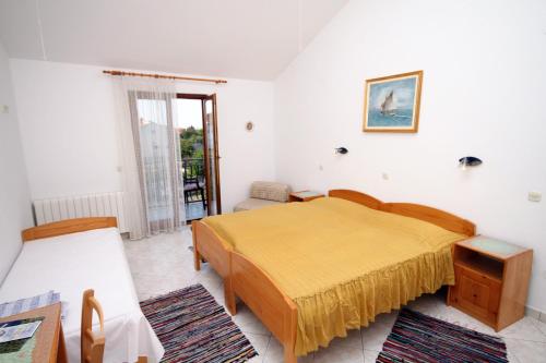 a bedroom with a bed and a couch and a window at Triple Room Gornje selo 5170d in Grohote