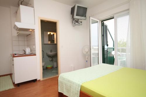 Ein weißes Zimmer mit einem Bett und einem Bad. in der Unterkunft Studio Brela 6907b in Brela