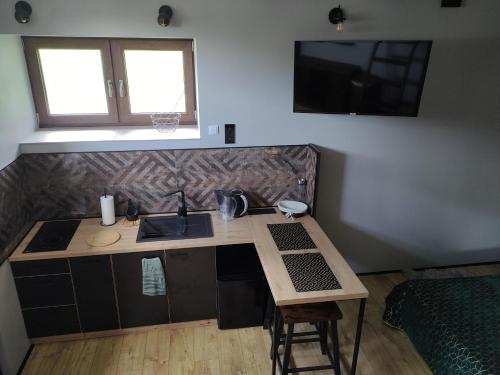 a kitchen with a counter and a sink and a table at Zdomek in Teplice nad Metují