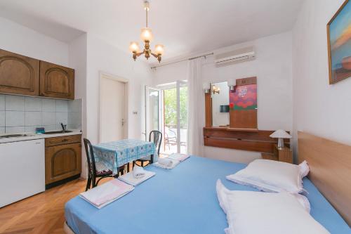 1 dormitorio con 2 camas, mesa y cocina en Studio Baska Voda 6773c, en Baška Voda