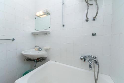 baño blanco con ducha y lavamanos en Studio Baska Voda 6773c, en Baška Voda