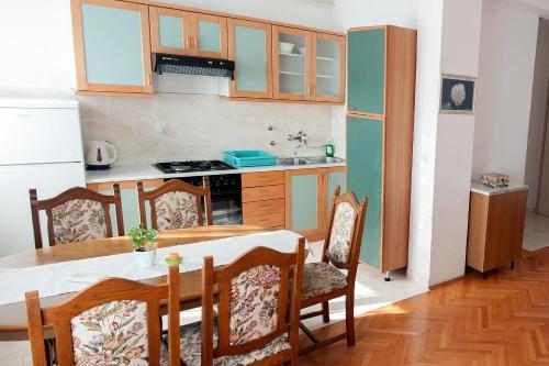 cocina con mesa y sillas y cocina con nevera en Studio Turanj 6445b, en Turanj
