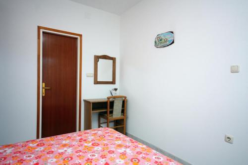 Schlafzimmer mit einem Bett, einem Spiegel und einer Tür in der Unterkunft Double Room Palit 5044b in Rab