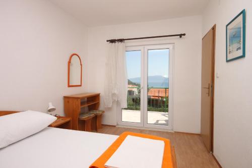 1 dormitorio con 1 cama y puerta corredera de cristal en Double Room Gradac 6819a, en Gradac