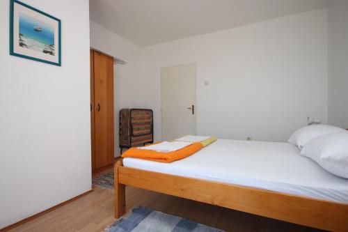 a bedroom with a bed with an orange blanket on it at Double Room Gradac 6819a in Gradac