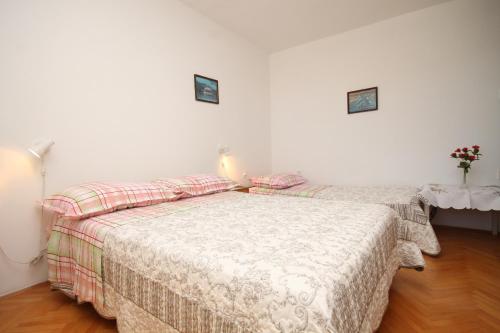 a bedroom with two beds and a table with a lamp at Studio Tucepi 6857b in Tučepi
