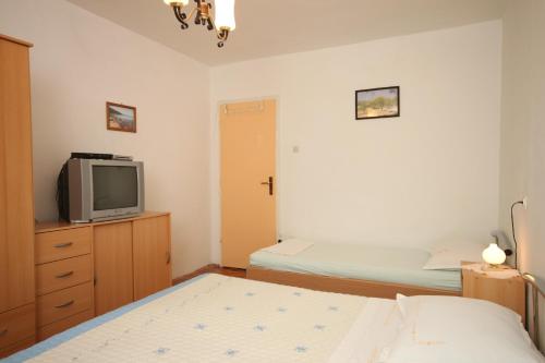 ein kleines Schlafzimmer mit 2 Betten und einem TV in der Unterkunft Triple Room Sucuraj 6734c in Sućuraj
