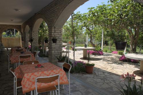 un patio esterno con tavoli, sedie e alberi di Triple Room Povljana 6476b a Povljana (Pogliana)