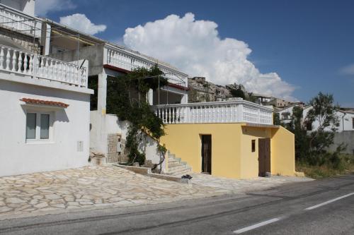 a yellow and white building on the side of a street at Double Room Metajna 6496b in Metajna