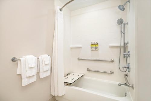 a bathroom with a shower and a bathtub with towels at Holiday Inn Express & Suites Florence, an IHG Hotel in Florence