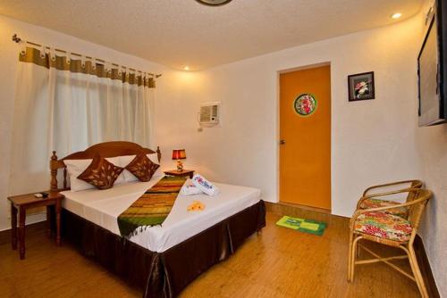 a bedroom with a bed and a chair in it at Floral Villarosa in Puerto Princesa City