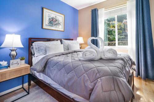 een blauwe slaapkamer met een bed en een raam bij Entire house with Four Bedrooms, Hot Tub, BBQ, Private Backyard, FREE WiFi and Parking, near Seattle, EV in Lynnwood