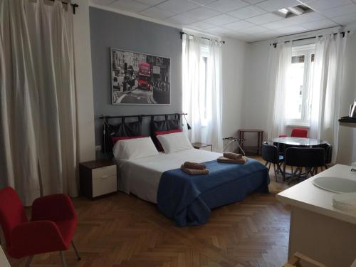a bedroom with a bed and a table and chairs at Piazza Goldoni Rooms in Trieste