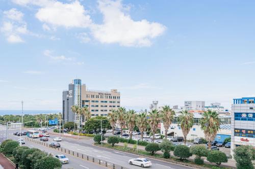 a busy city street with cars on the road at Jeju Miracle Hotel in Jeju