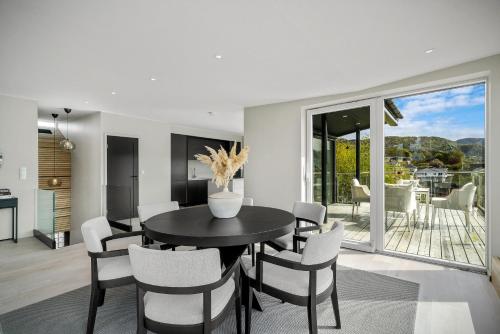 a dining room with a black table and white chairs at "Villa Bergen" 2min from beach & 10min from city centre in Bergen