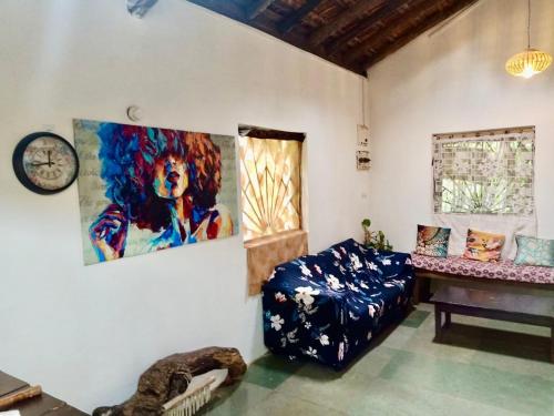 a room with a chair and a painting on the wall at The Wild Flower! in Anjuna
