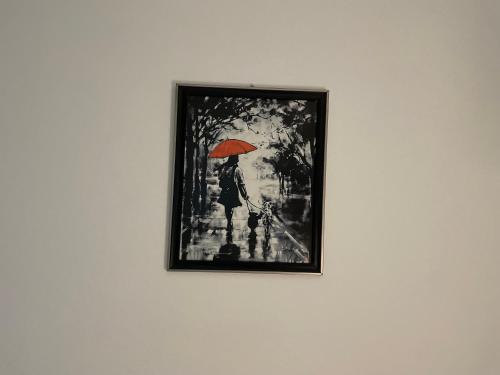 ein Bild einer Frau mit einem Regenschirm an der Wand in der Unterkunft Restaurant - Rooms "Pače 027" Restoran - Prenociste in Kuršumlija