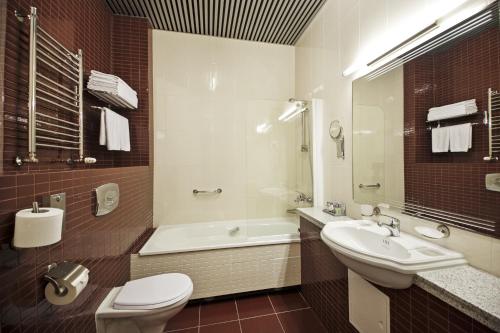 ein Badezimmer mit einer Badewanne, einem Waschbecken und einem WC in der Unterkunft Victoria Hotel & Business centre Minsk in Minsk