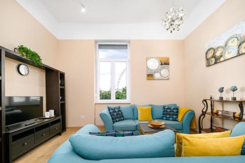 een woonkamer met blauwe banken en een tv bij JA18 Downtown Pearl - 2 bedroom apartment in Boedapest