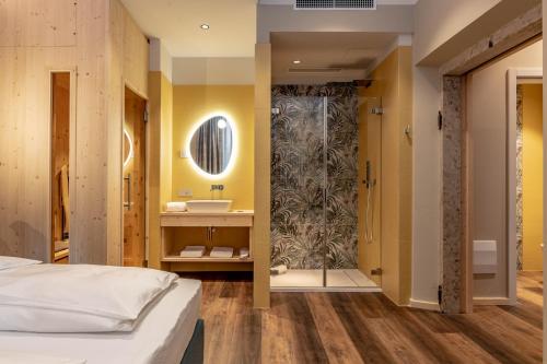 特倫托的住宿－Calepina Alpine Suite，一间卧室配有一张床,浴室设有淋浴。