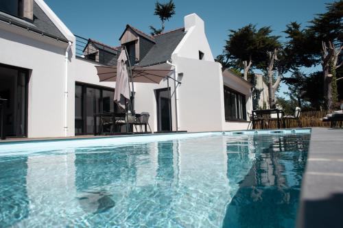 une piscine devant une maison dans l'établissement La Villa Métairie, à Locmaria