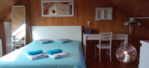 1 dormitorio con cama con almohadas y mesa en Pokoje Gościnne - U Wiktorii, en Krynica Morska