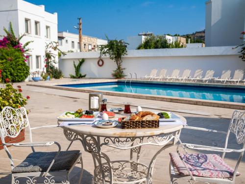 een tafel met eten erop naast een zwembad bij Seckin Konaklar in Bodrum City