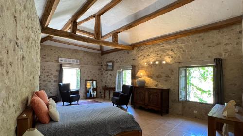1 dormitorio con 1 cama y sillas en una habitación en Moulin Sainte Anne, en Grasse